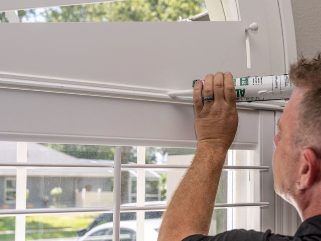 A VU installer finishing a new window treatment in an Apopka home
