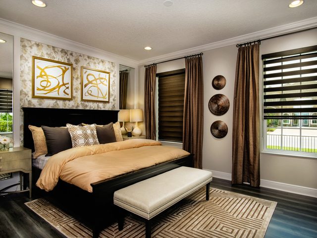 Dual zebra shades layering sheer and solid bands in a warm bedroom