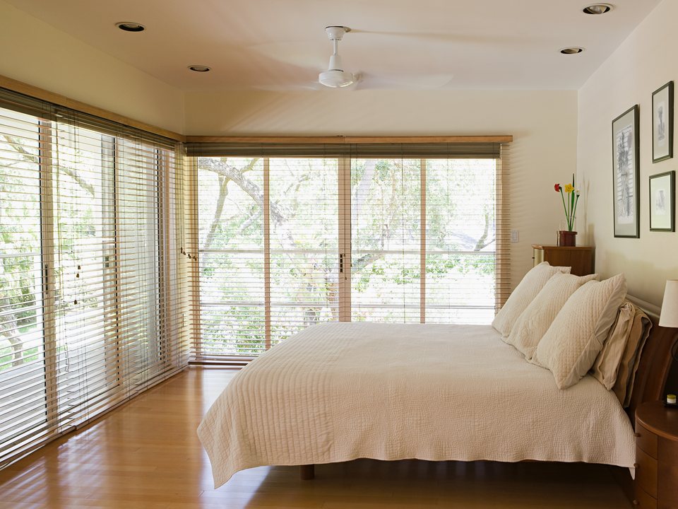 New construction bedroom with faux wood blinds on the sliding doors in Apopka, FL